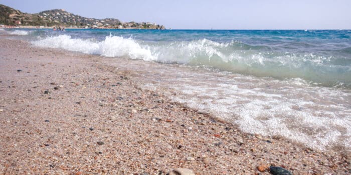 Sardegna, Spiaggia di Kal’e Moru - Sardaigne, Plage Kal’e Moru. Vagues et écume. Sable fin et cailloux à la plage.