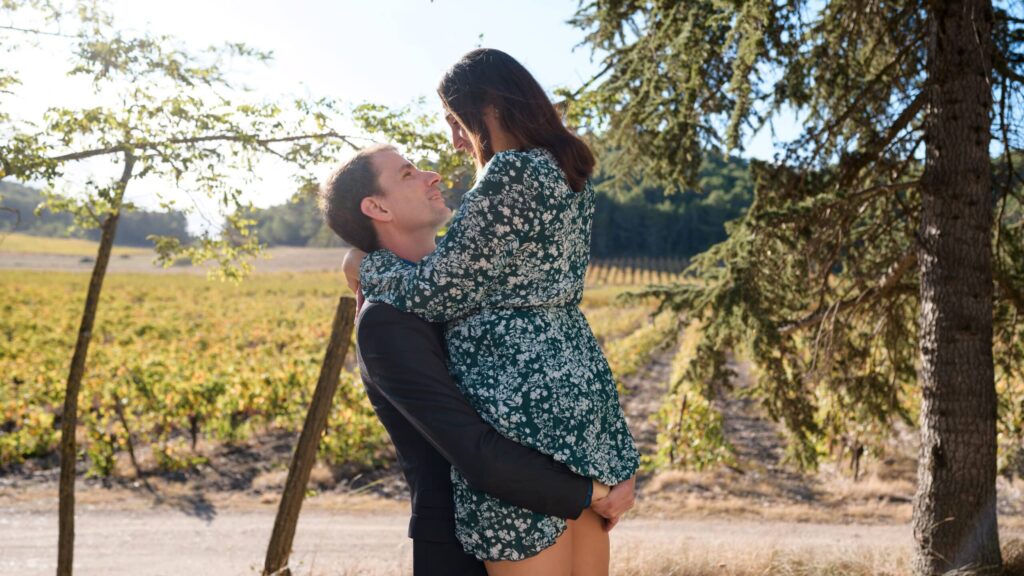 séance photo de couple, ils sont dans les bras l'un de l'autre. Ils se regardent dans les yeux et se sourient.