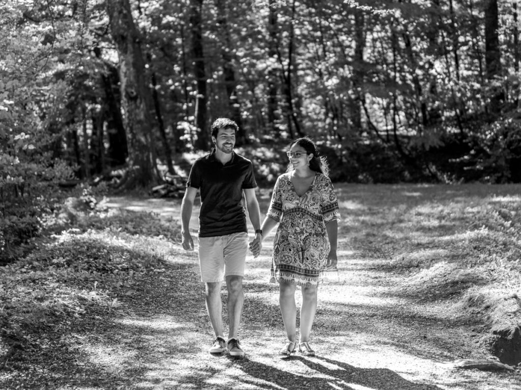 Séance photo de couple à la Rigole, dans la Montagne Noire. photo en noir et blanc. Le couple marche main dans la main. Ils sourient tous les deux.