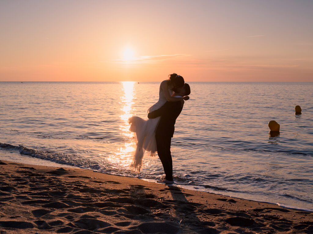 Photos de couple au lever de soleil à la plage. Day after ponton Leucate. Elle porte une robe Carrière mariage à Villefranche de Lauragais