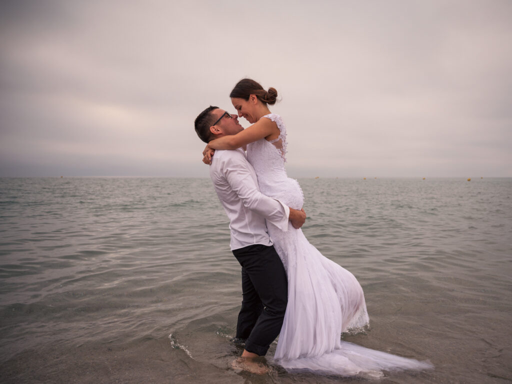 photos de couple en tenue de mariés pour leur anniversaire de mariage. cadeau d'anniversaire noces de Chypre. photos réalisées en extérieur, au ponton de Port Leucate