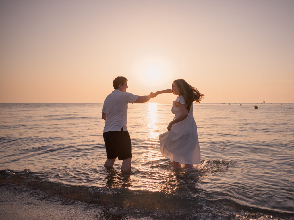 Photos de fiançailles au bord de la mer : la séance de Claire & Luc à Leucate. Séance engagement au lever de soleil au ponton de Leucate. Robe : Aym studio. Bague de fiançailles : Deloison Paris.