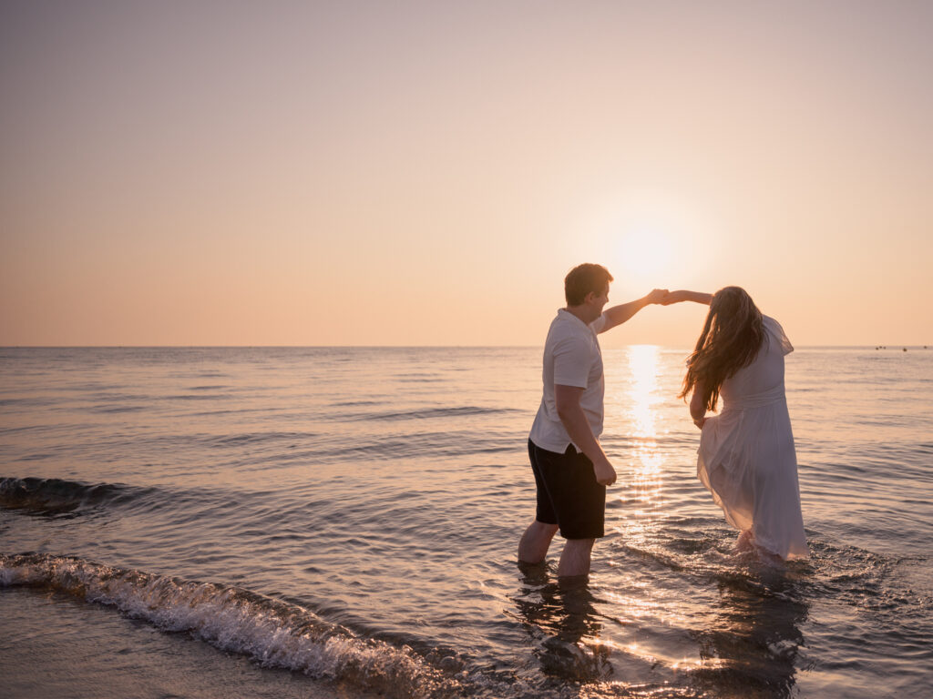 Photos de fiançailles au bord de la mer : la séance de Claire & Luc à Leucate. Séance engagement au lever de soleil au ponton de Leucate. Robe : Aym studio. Bague de fiançailles : Deloison Paris.