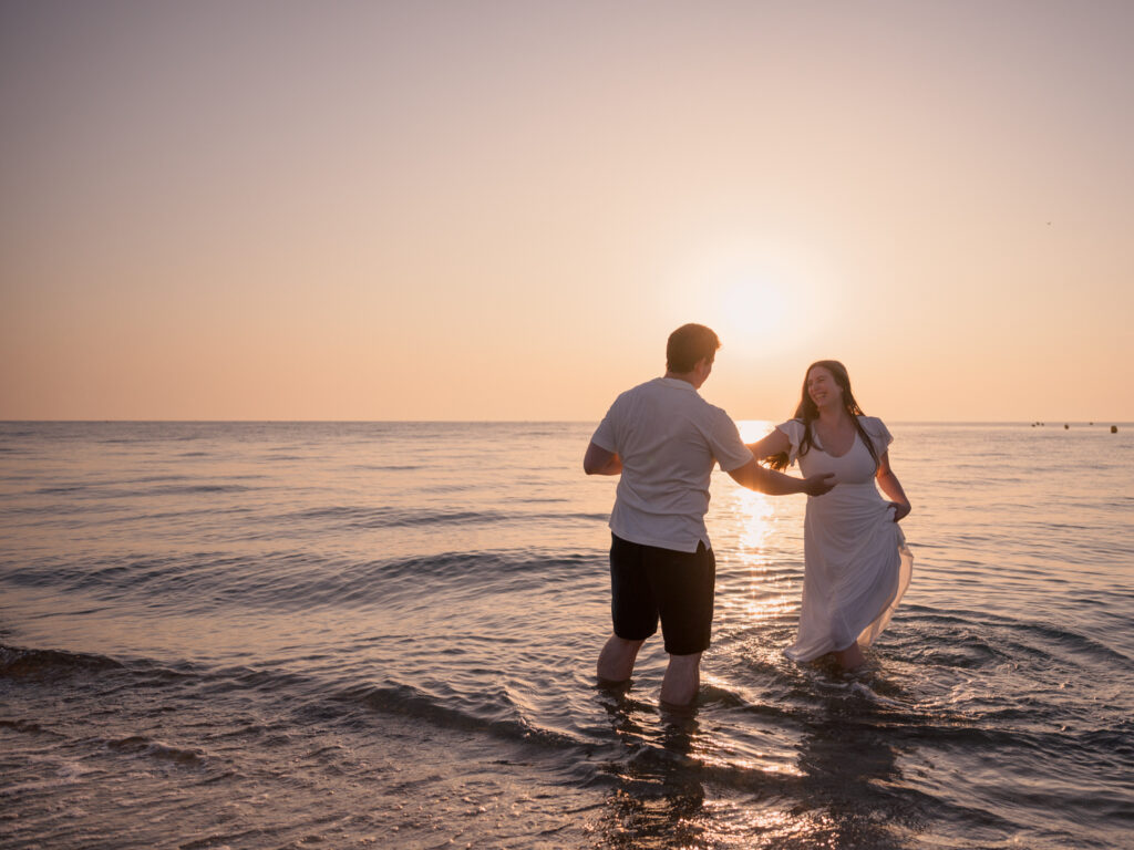 Photos de fiançailles au bord de la mer : la séance de Claire & Luc à Leucate. Séance engagement au lever de soleil au ponton de Leucate. Robe : Aym studio. Bague de fiançailles : Deloison Paris.