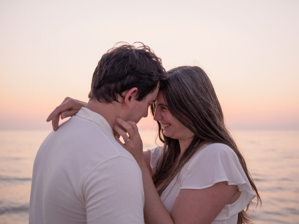 Photos de fiançailles au bord de la mer : la séance de Claire & Luc à Leucate. Séance engagement au lever de soleil au ponton de Leucate. Robe : Aym studio. Bague de fiançailles : Deloison Paris.