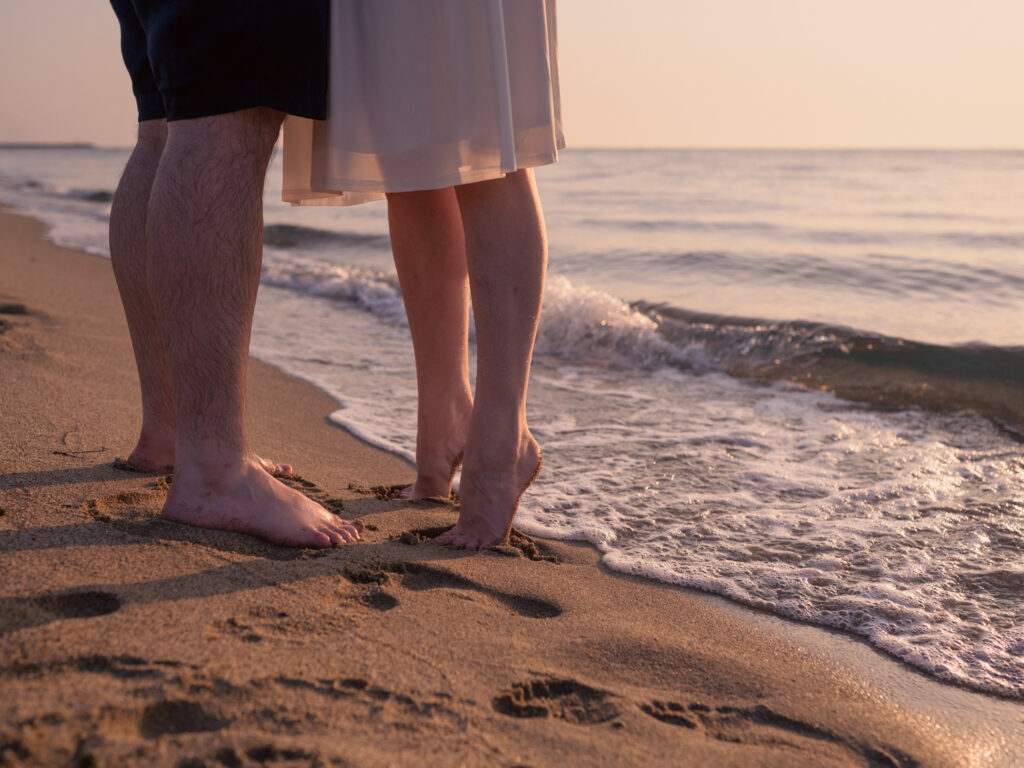 Photos de fiançailles au bord de la mer : la séance de Claire & Luc à Leucate. Séance engagement au lever de soleil au ponton de Leucate. Robe : Aym studio. Bague de fiançailles : Deloison Paris.