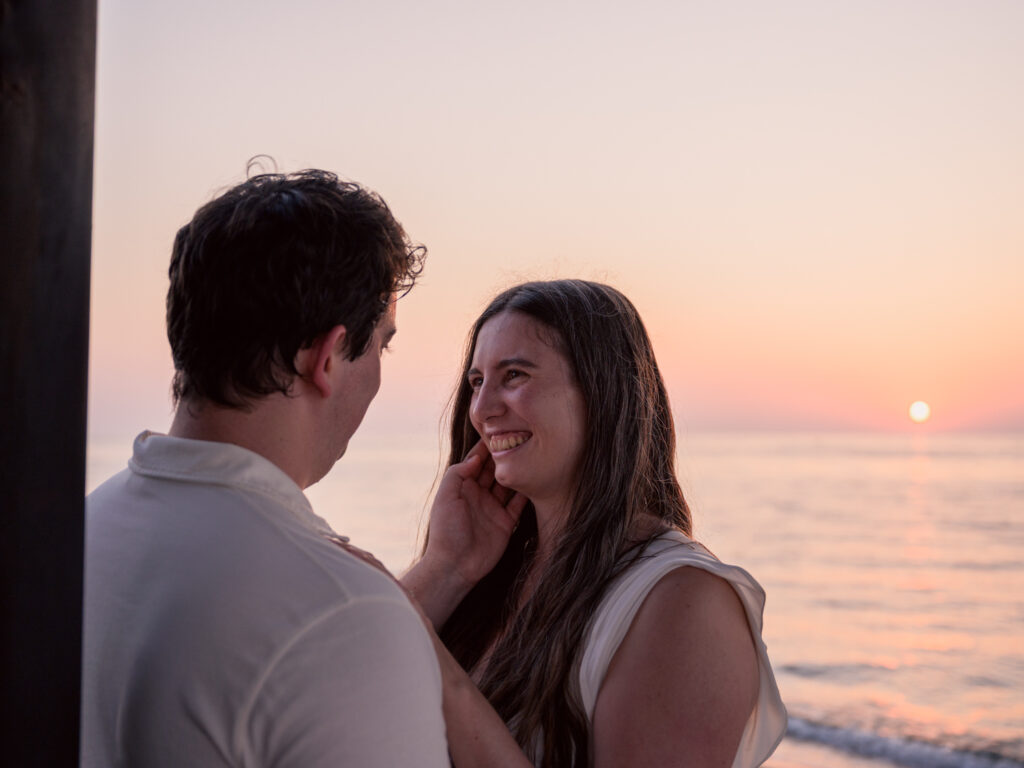 Photos de fiançailles au bord de la mer : la séance de Claire & Luc à Leucate. Séance engagement au lever de soleil au ponton de Leucate. Robe : Aym studio. Bague de fiançailles : Deloison Paris.